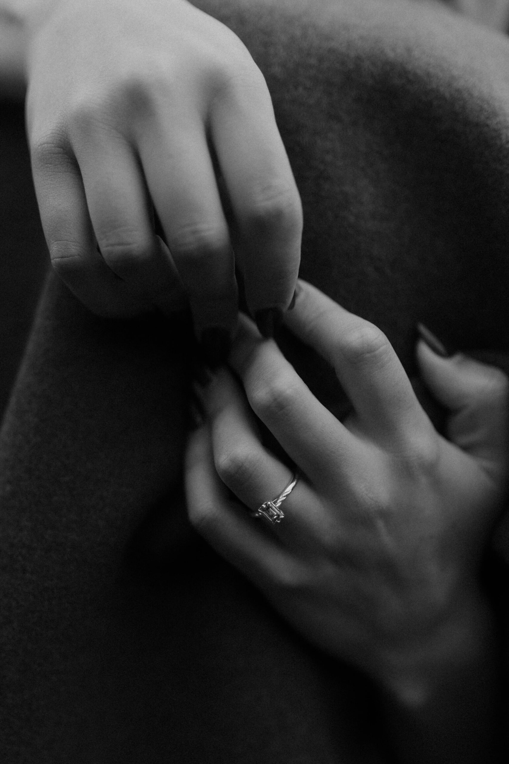 Close-up of intertwined hands during an Isle of Skye couples photoshoot, highlighting the engagement ring in a fine art, cinematic style by Aly Robinson Photography.