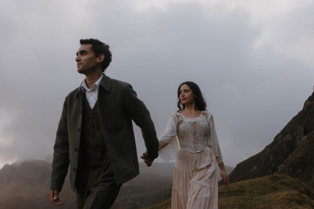 Couple walking together during a fine art Isle of Skye photoshoot on the Quiraing, captured by Scotland elopement photographer Aly Robinson.