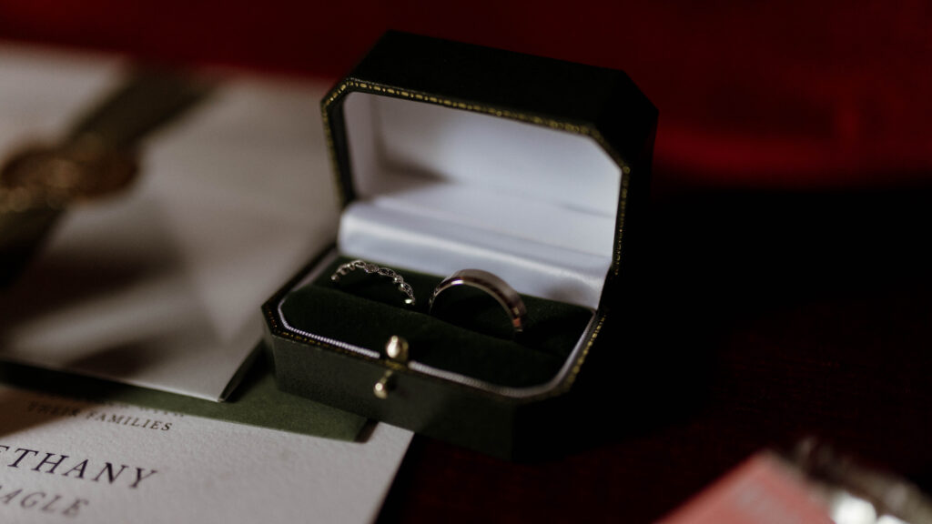 Fine art wedding detail of rings in a dark green velvet box, photographed by a luxury Scotland wedding photographer Aly Robinson in a cinematic, dark romantic style.