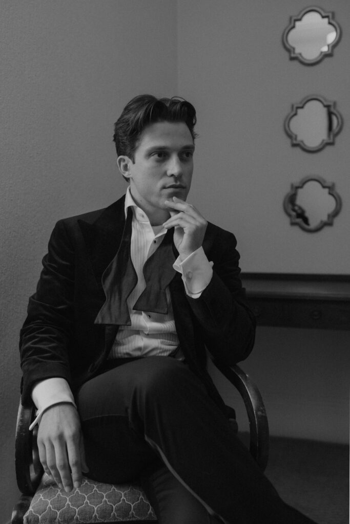 Elegant black and white portrait of a groom in a velvet jacket, captured in a dark academia style by luxury fine art Scotland wedding photographer Aly Robinson.