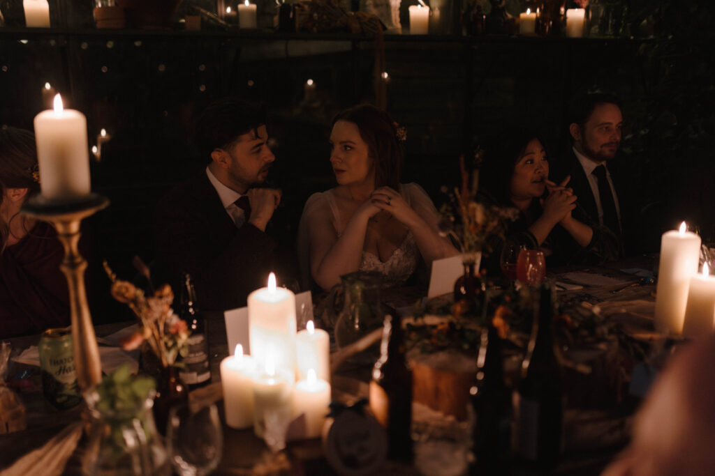 Cinematic wedding dinner scene with soft candlelight and natural conversation between guests, captured by Aly Robinson, Scotland wedding photographer.