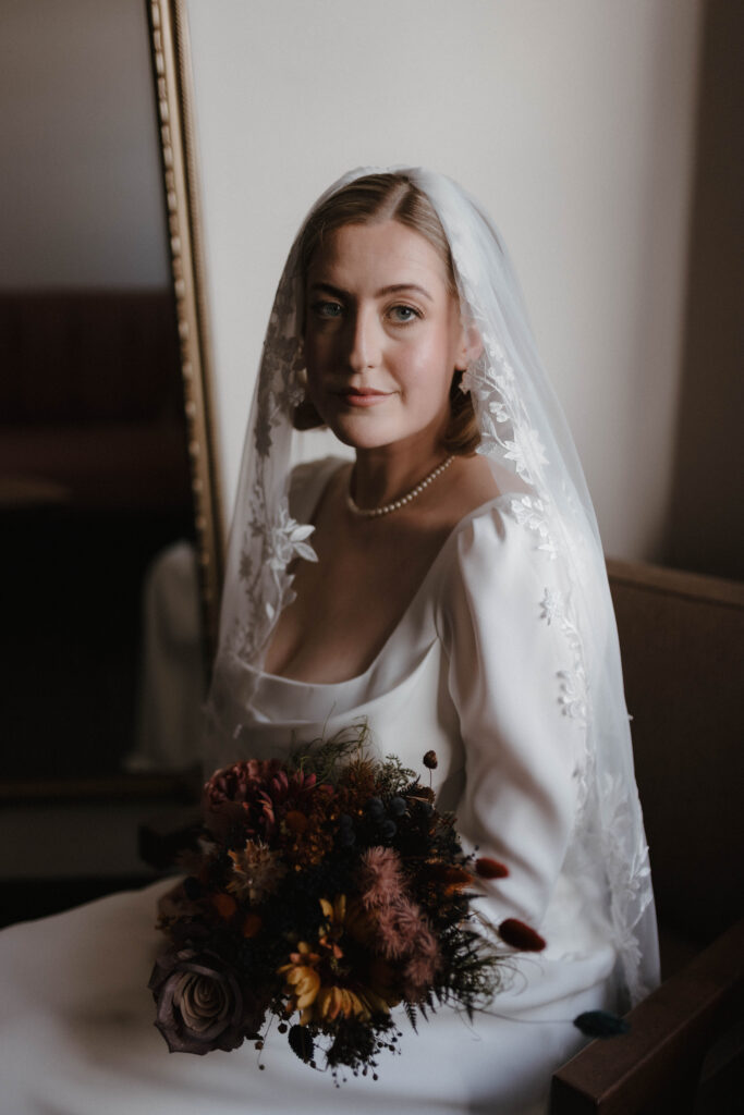 Fine art bridal portrait of a bride in a classic veil and long-sleeved gown, photographed by Scotland wedding photographer Aly Robinson in soft natural light.