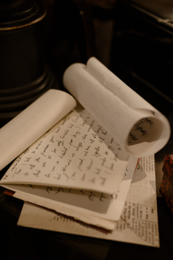 Handwritten love letters and parchment scrolls styled on antique desk for cinematic editorial wedding photography at Prestonfield House Edinburgh