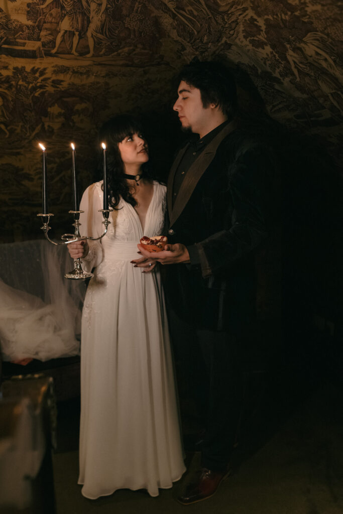 Bride and groom standing together by candlelight inside Prestonfield House Edinburgh during a cinematic luxury wedding photography portrait session