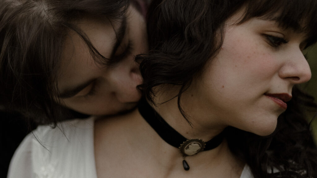 Close up of groom kissing bride’s neck with vintage cameo choker during an intimate cinematic couple portrait at Prestonfield House Edinburgh wedding photography