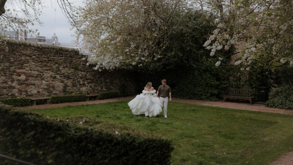 Luxury engagement photography in Edinburgh by Aly Robinson featuring couple walking through a private garden in Scotland
