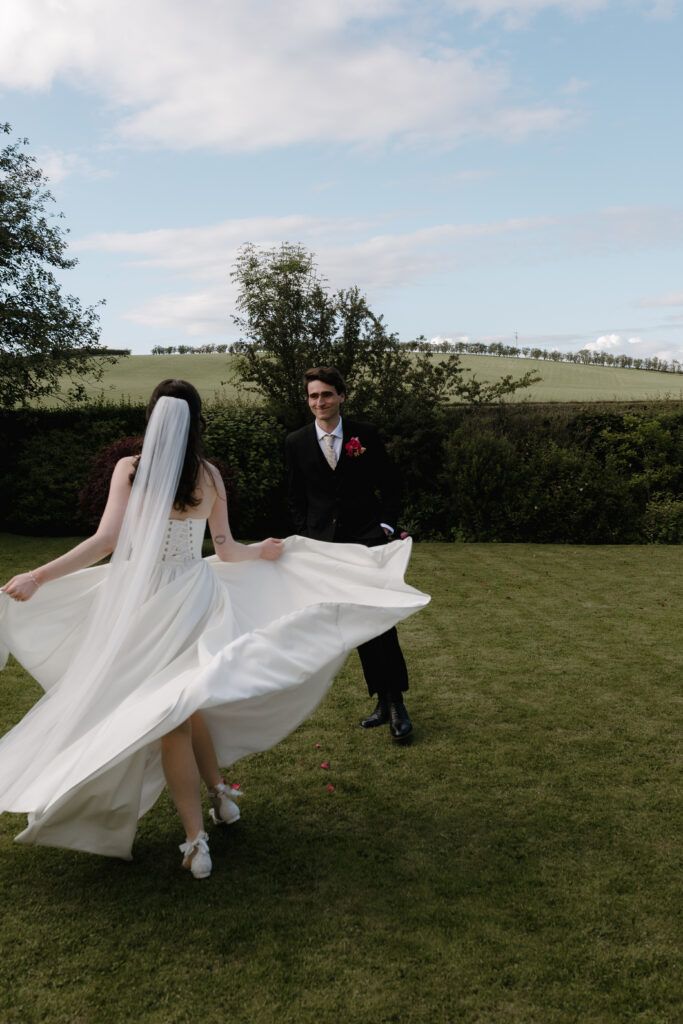 Bride twirling her wedding dress during playful couple portraits at a colourful Dalduff Farm wedding near Glasgow